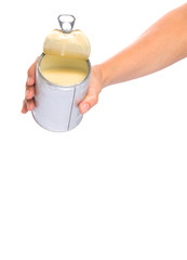 Female hand pouring condensed milk over white background