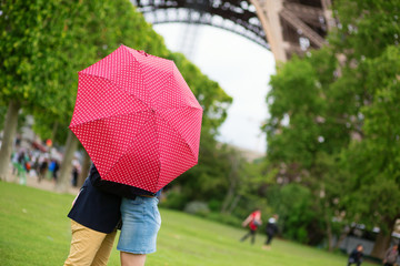Couple in Paris kissing under the rain