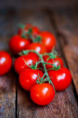 Tomatoes on the vine on rustic wooden background
