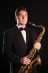 Fototapeta na wymiar Saxophonist on a black background