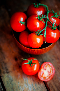 Tomatoes in the basket on wooden background