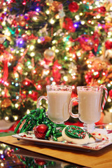 Mugs of egg nog with Christmas tree background