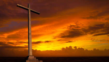 Christian cross on sunset sky. Religion background.