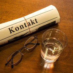 kontakt, schreibtisch mit glas und brille