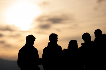 silhouetted group in sunset sky