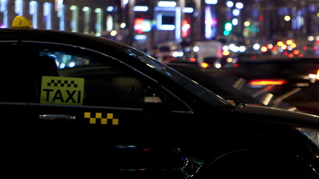 Timelapse of city traffic at night behind taxi car