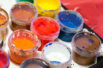 Colorful acrylic paints in small plastic cans