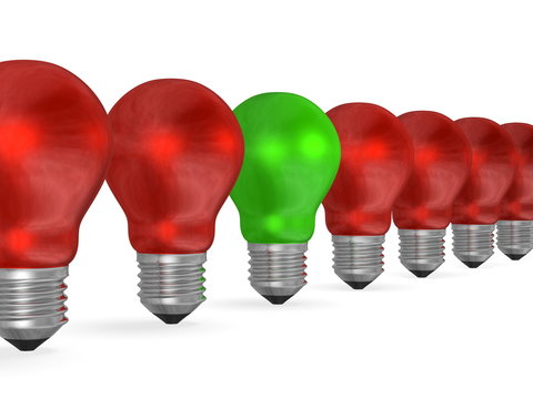 One green light bulb in row of many red ones