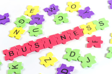 word BUSINESS formed with colorful foam puzzle  on white backgro