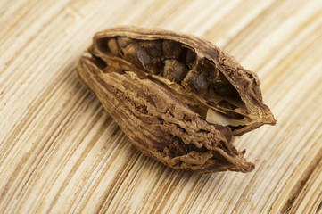 Black cardamom pods on wooden background