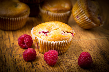 Raspberry muffins on wooden background