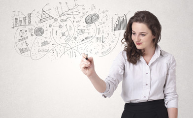 Pretty girl sketching graphs and diagrams on wall