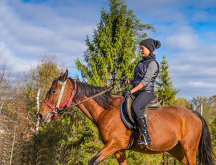 Fototapeta premium Elegant attractive woman riding a horse