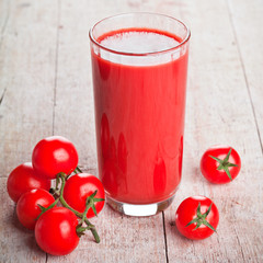 tomato juice in glass and fresh tomatoes