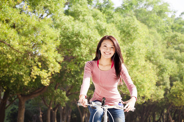 Happy young girl with bicycle outdoor portrait.