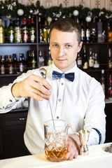 young man working as a bartender in a nightclub bar