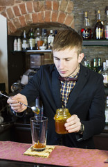 young man working as a bartender in a nightclub bar