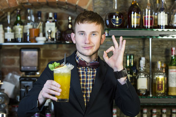 young man working as a bartender in a nightclub bar