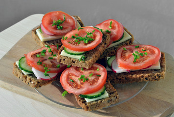 Wholemeal rye bread sandwich with tomato, cucumber, radish and c