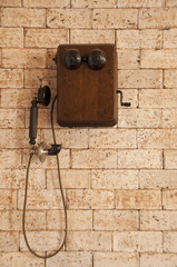 Antique telephone on brick wall.