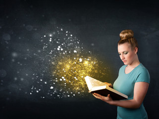 Young lady reading a magical book