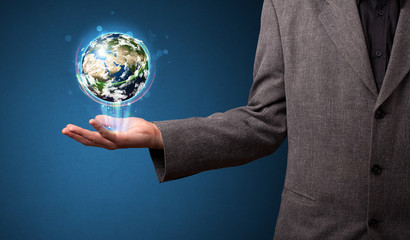 Businessman holding glowing earth globe