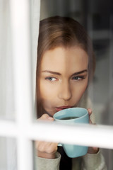 Beautiful caucasian woman drinking hot coffee or tea.