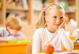 Children behind school desks during lesson
