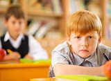 Children behind school desks during lesson
