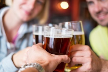 Friends with beer toasting in a pub