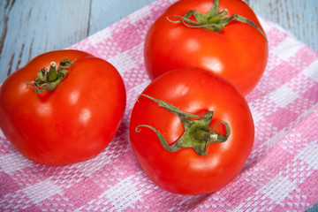 three tomatoes on a plaid towel