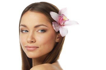 Fototapeta premium Young beautiful brunette woman with orchid flower