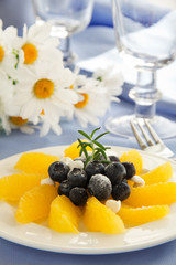 Delicious fruit salad with oranges, blueberries and cream.