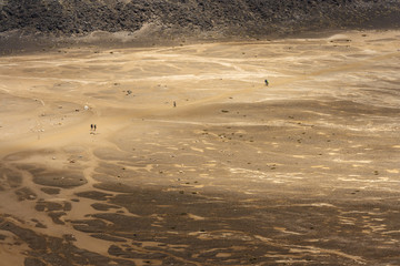 people walking accros barren land at Tongariro National Park
