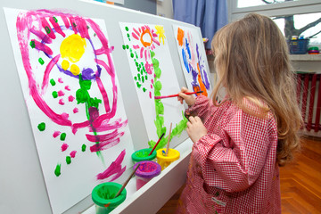 Little girl painting on paper