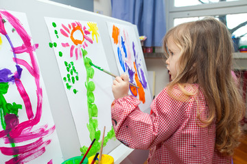 Little girl painting on paper