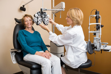Eye Specialist Adjusting Phoropter For Woman