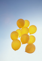 gelbe Luftballons im blauen Himmel