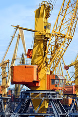 Port cargo crane over blue sky background