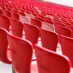 Red chairs bleachers in large stadium