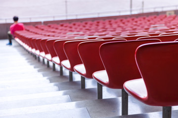 Red chairs bleachers in large stadium