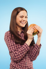 Girl eats a hamburger. Portrait in the studio. isolated
