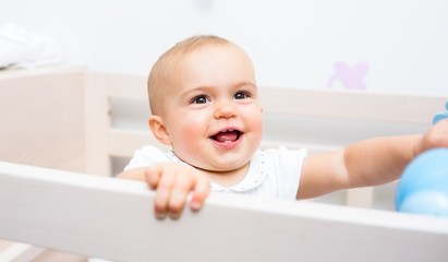 Close-up of a cheerful cute baby in the crib