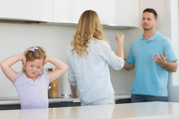 Girl covering ears while parents arguing