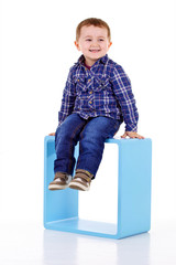 petit gar&ccedil;on assis sur un cube bleu
