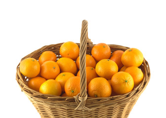 Many orange tangerines in big brown wicker basket isolated