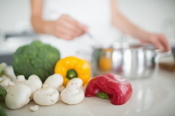 Obraz na płótnie Canvas Vegetables with blurred woman preparing food in kitchen