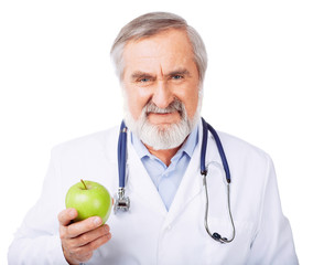Smiling doctor offering a green apple