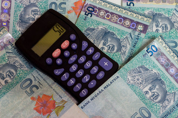 A calculator on a bank notes, ringgit malaysian currency.