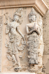 Stone praying women carvings on the wall of the temple in Thaila